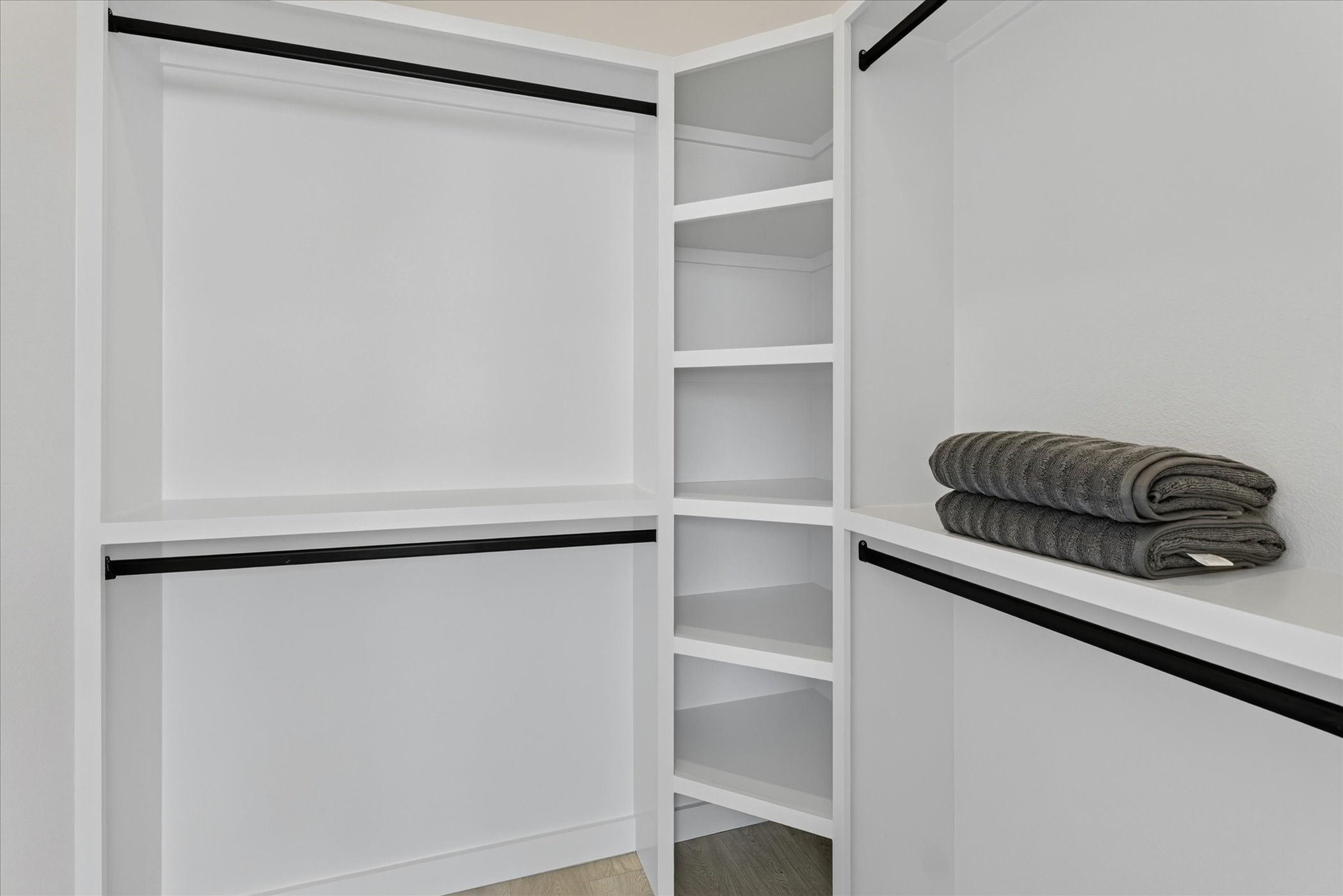 2000 Riverside Farms Road, Unit 8101 Austin, TX 78741 - Photo 31 of 41 This photo shows a spacious walk-in closet with white shelving and dual hanging rods, perfect for organizing clothes and accessories.