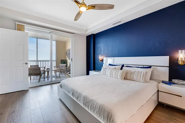 a large bedroom with bed and a chandelier