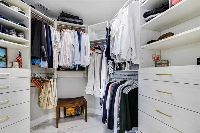 a view of walk in closet with clothes and shoes
