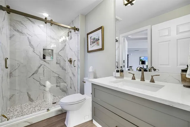 a bathroom with a sink a toilet and shower