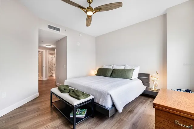 a bedroom with a bed window and wooden floor
