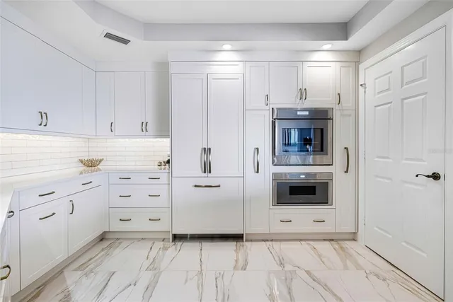 a kitchen with white cabinets and white appliances