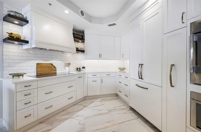 a kitchen with white cabinets and refrigerator