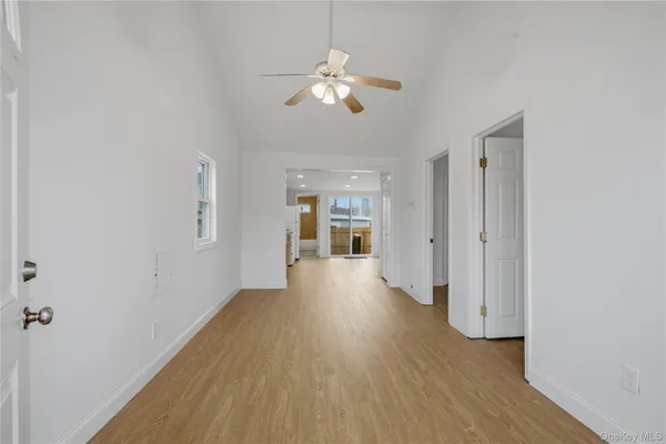 a view of a hallway with wooden floor and a chandelier