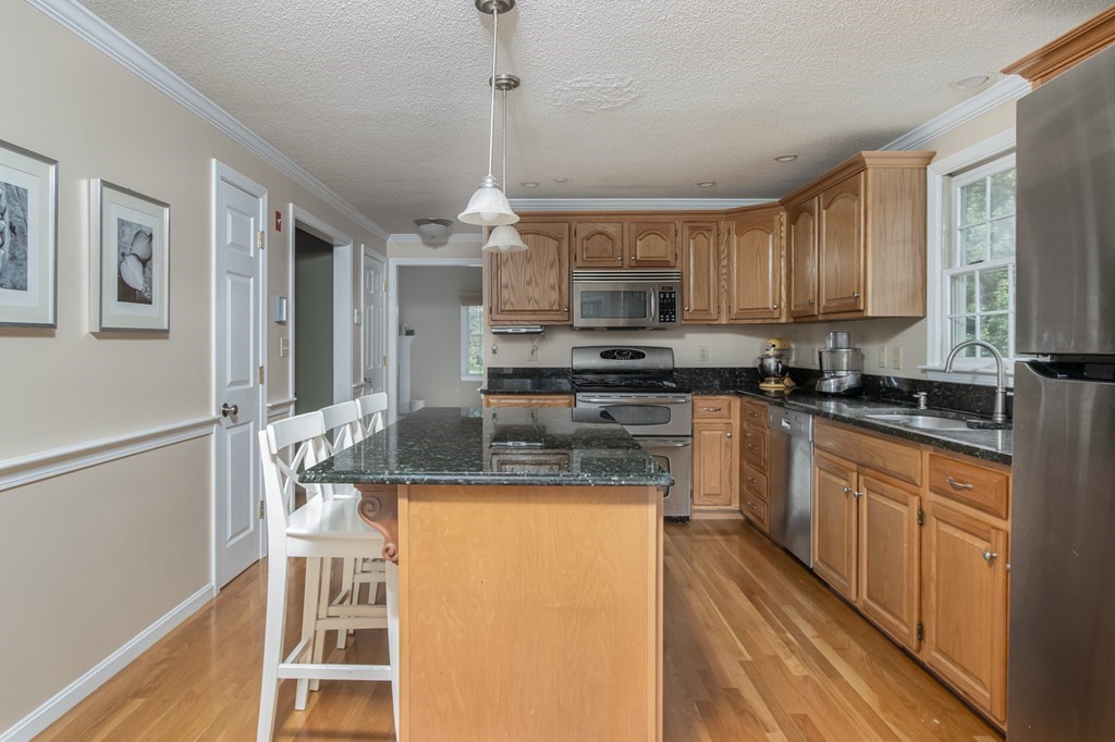 19 Hammond Farm Road Haverhill, MA 01832 - Photo 12 of 42 a kitchen with kitchen island granite countertop wooden cabinets and refrigerator