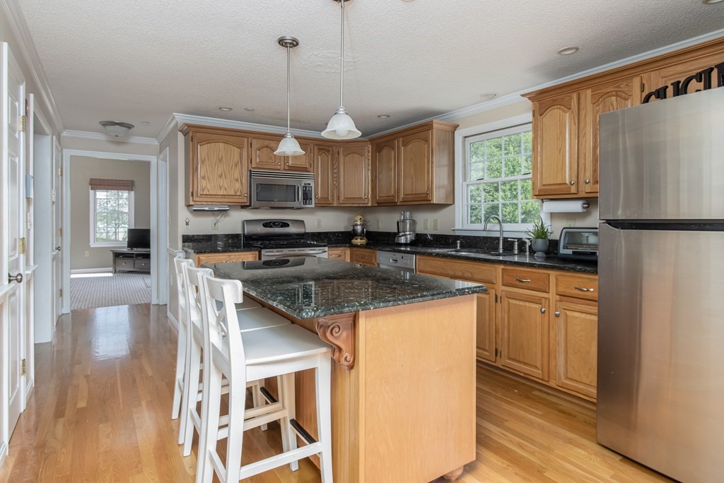 19 Hammond Farm Road Haverhill, MA 01832 - Photo 13 of 42 a kitchen with stainless steel appliances granite countertop a stove a sink dishwasher a refrigerator and white cabinets with wooden floor