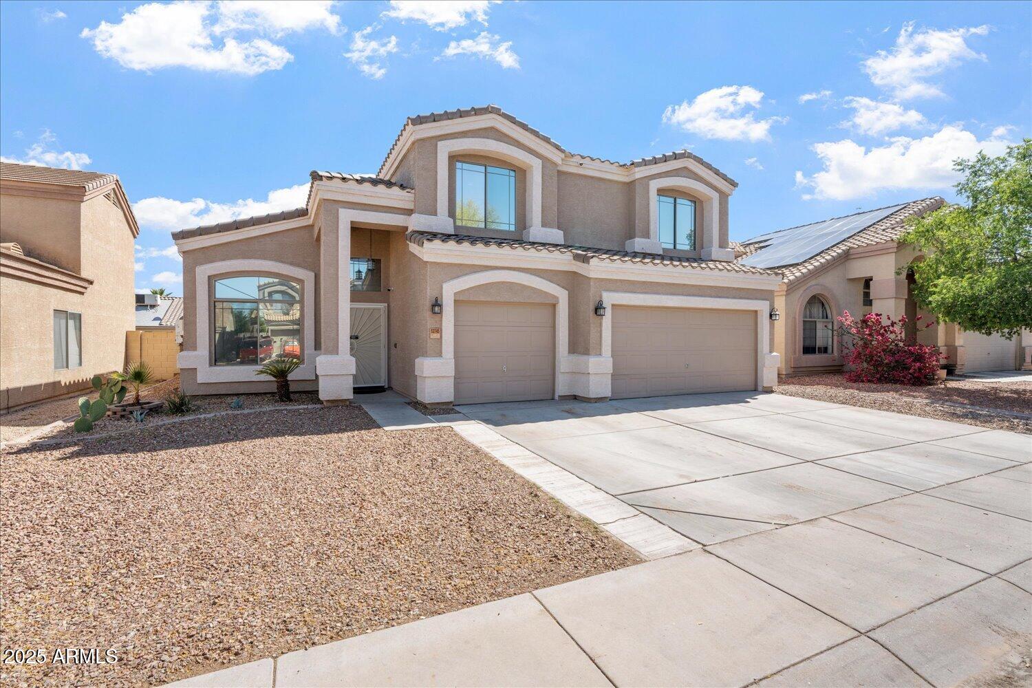 12745 West Calavar Road El Mirage, AZ 85335 - Photo 1 of 56 a front view of a house with a yard