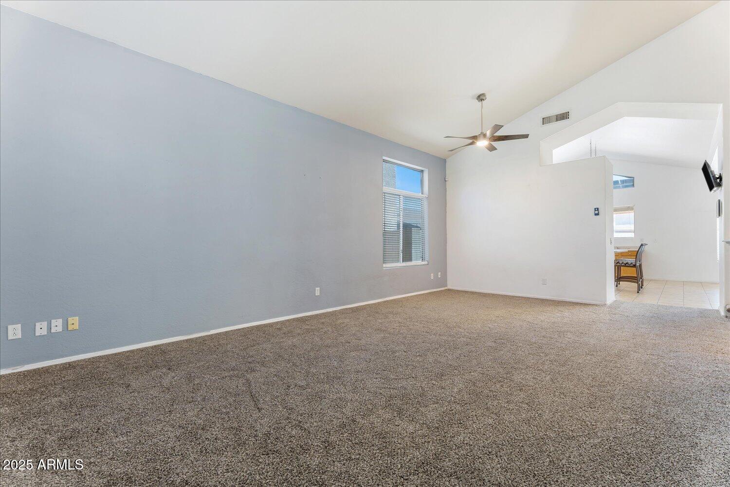 12745 West Calavar Road El Mirage, AZ 85335 - Photo 14 of 56 a view of a big room with windows and chandelier fan