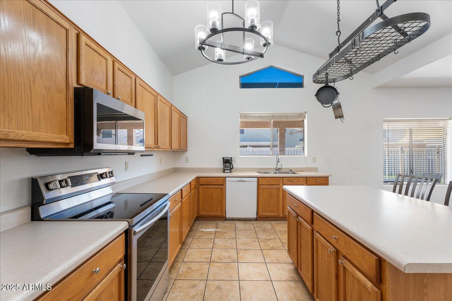 12745 West Calavar Road El Mirage, AZ 85335 - Photo 17 of 56 a kitchen with stainless steel appliances granite countertop a sink a stove oven a counter space and cabinets