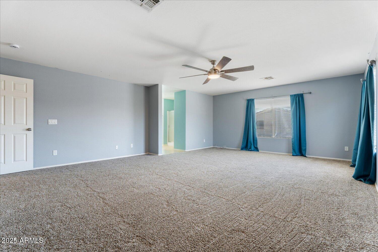 12745 West Calavar Road El Mirage, AZ 85335 - Photo 26 of 56 a view of an empty room with a chandelier fan