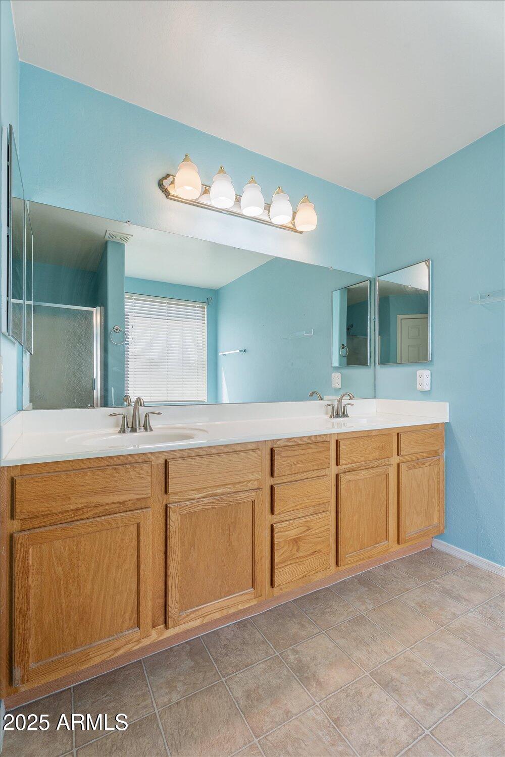 12745 West Calavar Road El Mirage, AZ 85335 - Photo 28 of 56 a spacious bathroom with a granite countertop sink a mirror and a