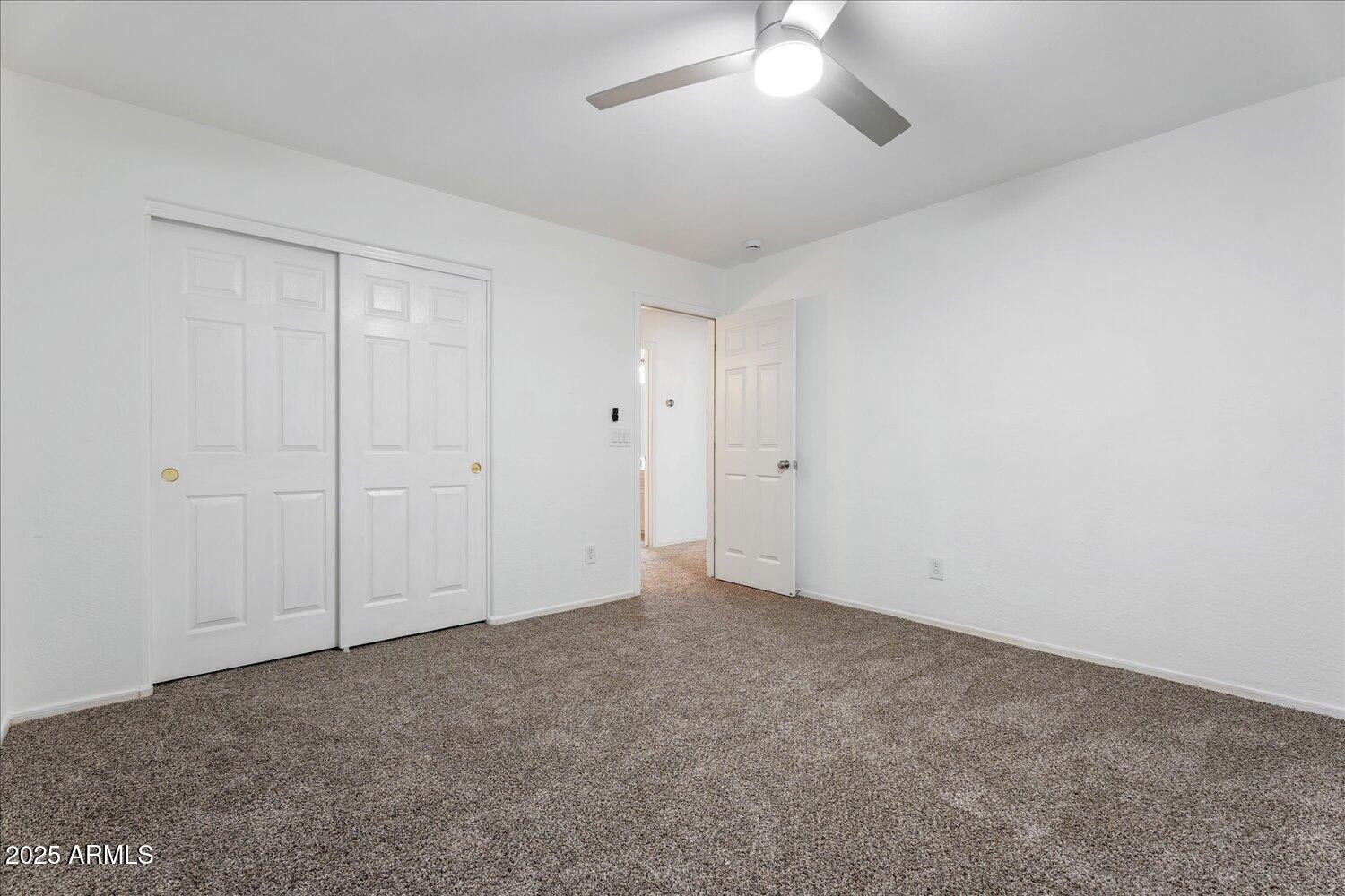 12745 West Calavar Road El Mirage, AZ 85335 - Photo 38 of 56 an empty room with a ceiling fan and a window