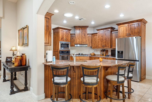 1609 East 10 S Street St. George, UT 84790 - Photo 18 of 68 Well-appointed kitchen featuring a large peninsula with countertop seating, stainless steel appliances, recessed lighting, and rich wood cabinetry