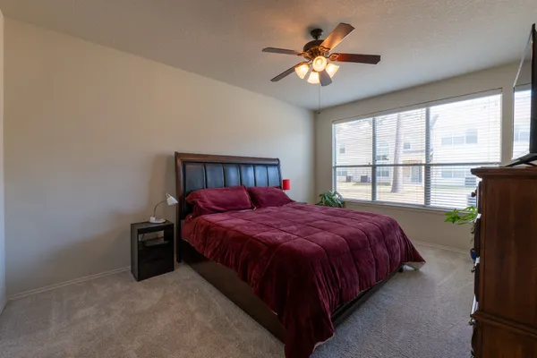a bedroom with a bed and a large window