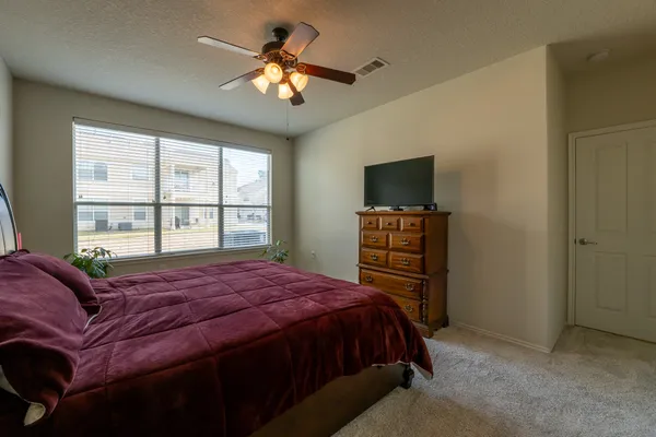a bedroom with a bed dresser and a window