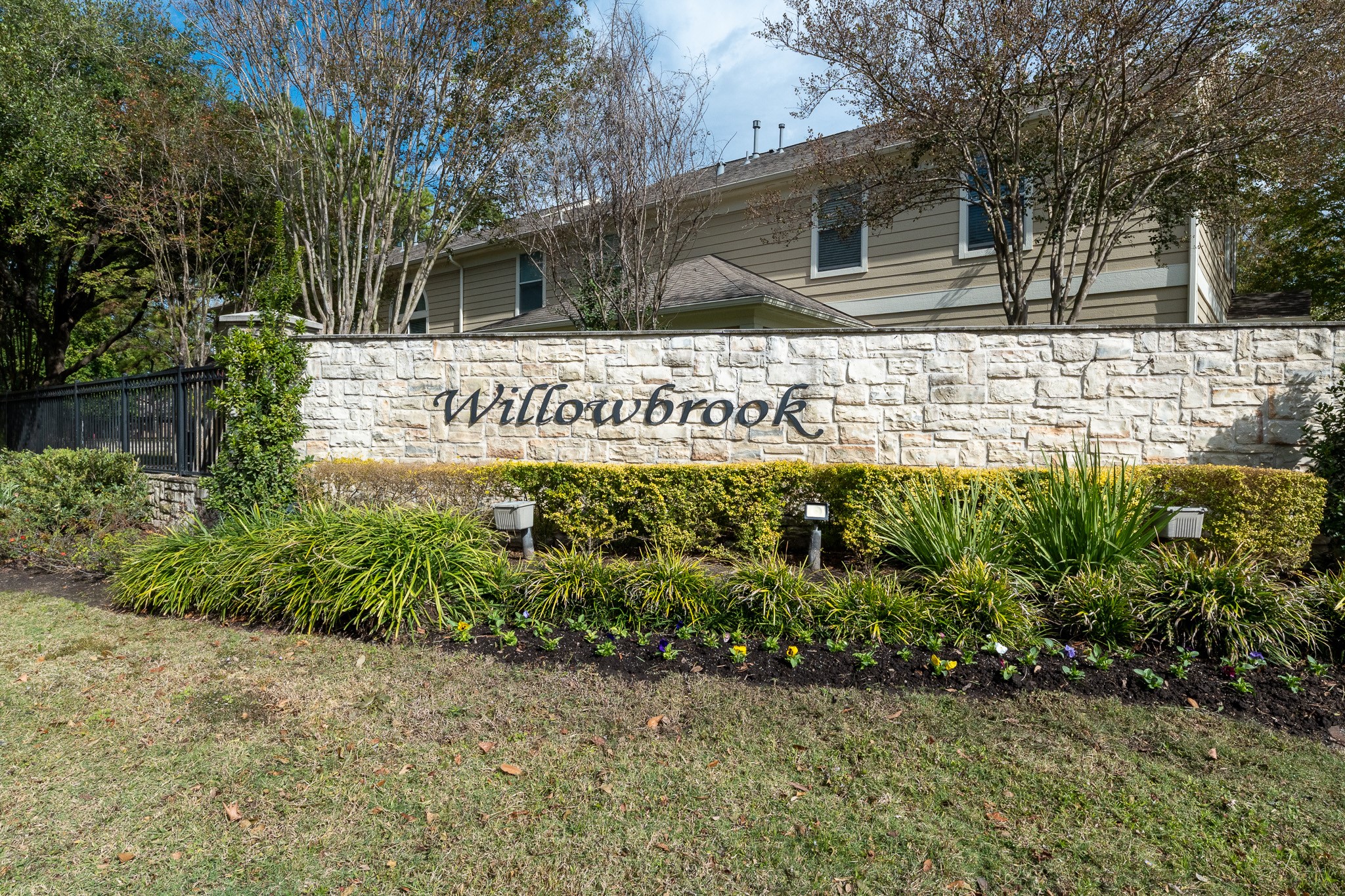 13600 Breton Ridge Street, Unit 29F Houston, TX 77070 - Photo 3 of 21 This photo shows the entrance to the Willowbrook community, featuring a stone wall with the community name and landscaped greenery, offering a welcoming and well-maintained appearance.