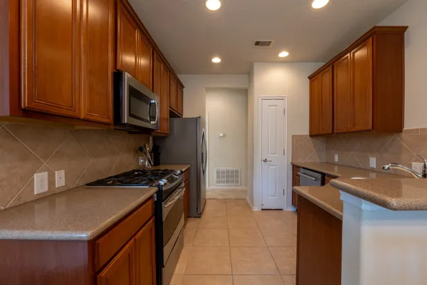 a kitchen with stainless steel appliances granite countertop a stove a sink and a microwave