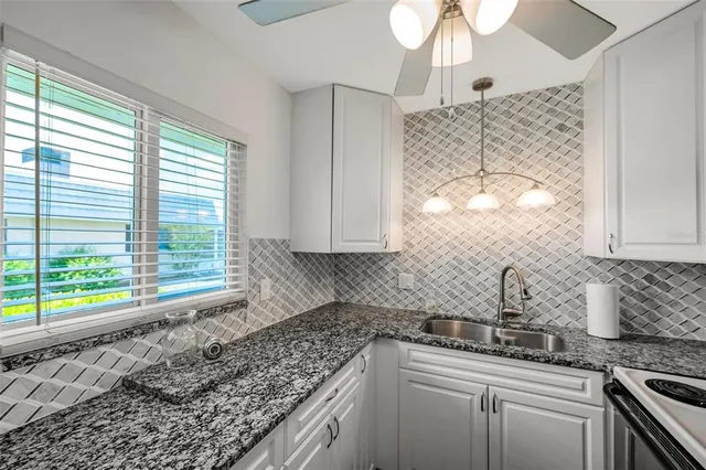 a bedroom with a bed a chandelier and a window