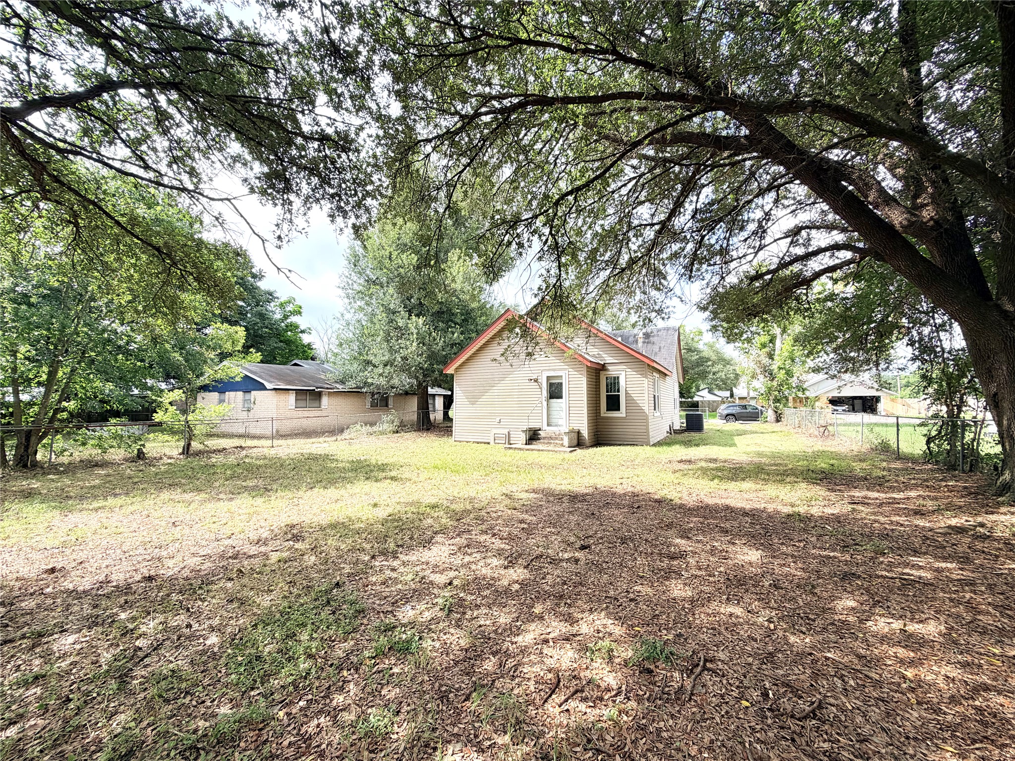 702 East 18th Street Cameron, TX 76520 - Photo 3 of 14 A quaint residence with a spacious backyard, shaded by mature trees.