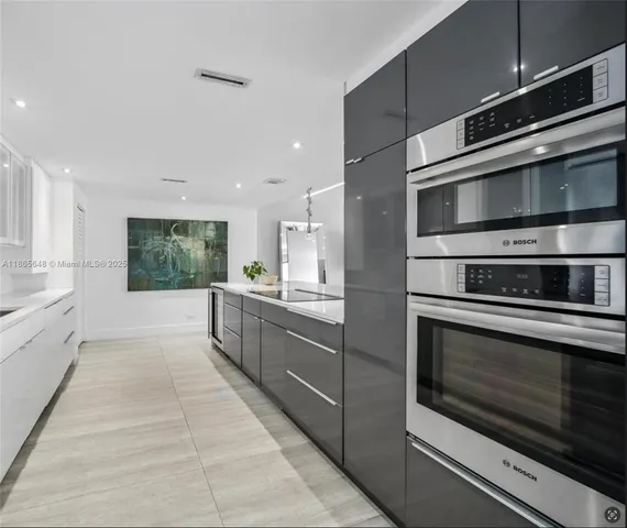 a kitchen with stainless steel appliances kitchen island granite countertop a stove and a sink