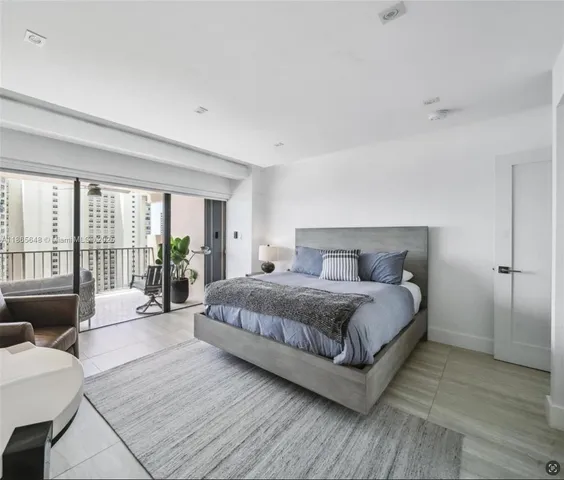 a spacious bedroom with a bed and wooden floor