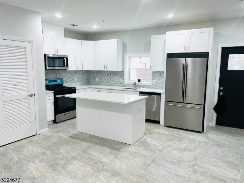 67 Wainwright Street, Unit 1 Newark, NJ 07112 - Photo 2 of 9 a kitchen with stainless steel appliances a refrigerator stove microwave and cabinets