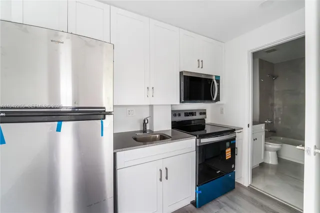 a kitchen with a refrigerator and a stove top oven