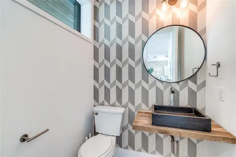 a bathroom with a toilet a sink and a mirror