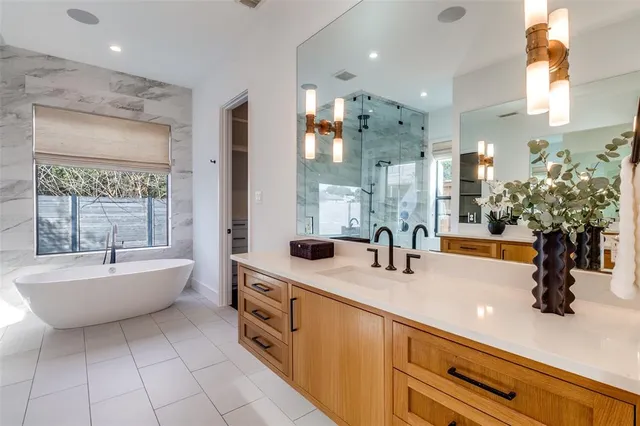 a bathroom with a double vanity sink a mirror and a bathtub
