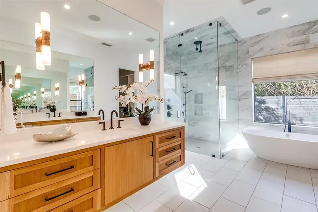a bathroom with a sink a large mirror and a bathtub