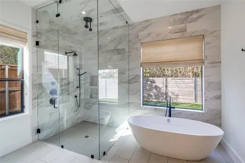 a spacious bathroom with a granite countertop tub shower and mirror