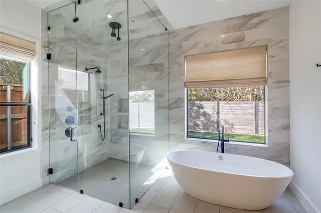 a spacious bathroom with a granite countertop tub shower and mirror