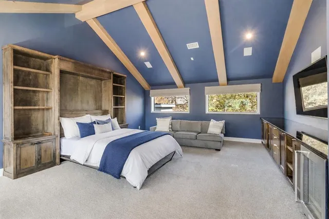 a spacious bedroom with a large bed and a flat screen tv