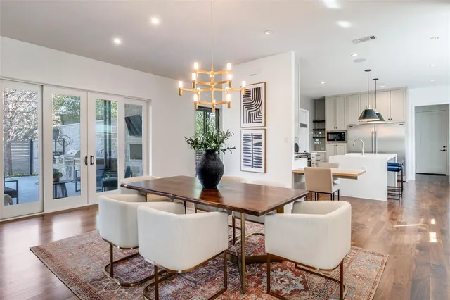 a dining room with furniture a chandelier and wooden floor