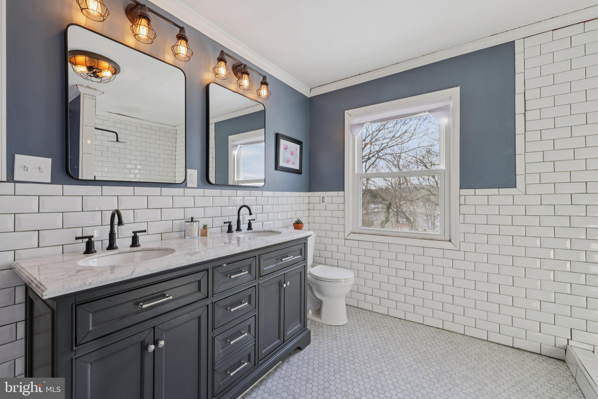 519 North Maple Avenue Brunswick, MD 21716 - Photo 15 of 26 a bathroom with a toilet sink double vanity and mirror