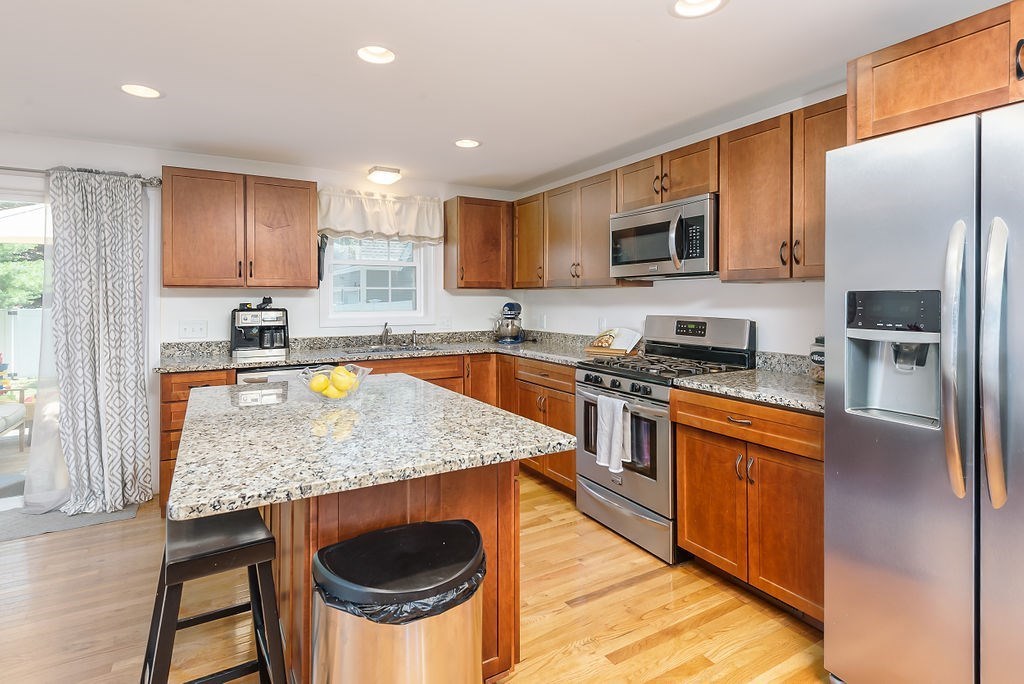 34 Bourne Avenue, Unit A Attleboro, MA 02703 - Photo 11 of 35 a kitchen with stainless steel appliances granite countertop a table chairs sink and cabinets
