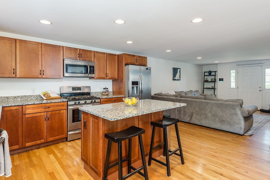 34 Bourne Avenue, Unit A Attleboro, MA 02703 - Photo 8 of 35 a kitchen with stainless steel appliances granite countertop a stove a sink a microwave a center island and a refrigerator