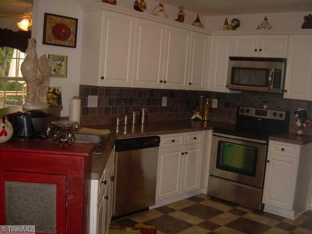 8107 Chestershire Road Oak Ridge, NC 27310 - Photo 2 of 11 Exterior Front. Renovated Chef s Kitchen with custom tiled floor, custom slate tiled backsplash & new stainless steel appliances.