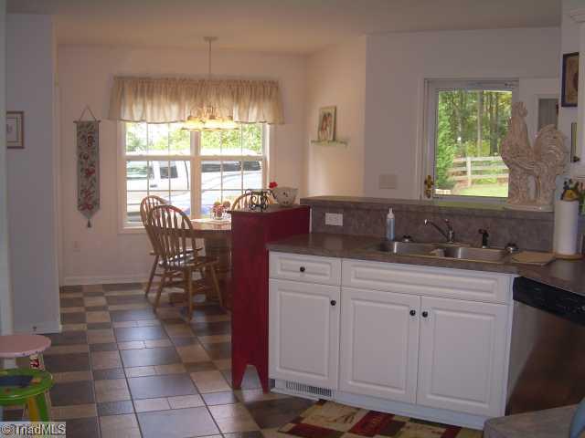 8107 Chestershire Road Oak Ridge, NC 27310 - Photo 3 of 11 Exterior Front. Additional Kitchen view opens to the Breakfast Room with a French door leading to the side covered porch.
