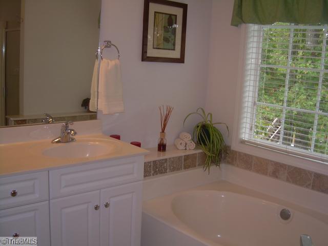 8107 Chestershire Road Oak Ridge, NC 27310 - Photo 5 of 11 Exterior Front. Master Bathroom has a garden bathtub with custom tile work, separate shower and a double raised vanity.