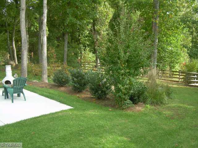 8107 Chestershire Road Oak Ridge, NC 27310 - Photo 7 of 11 Exterior Front. Privacy abounds in the fully fenced backyard. Fabulous combination of level area, rolling hills, mature hardwood trees and wired 12x14 storage building with window & potting bench.