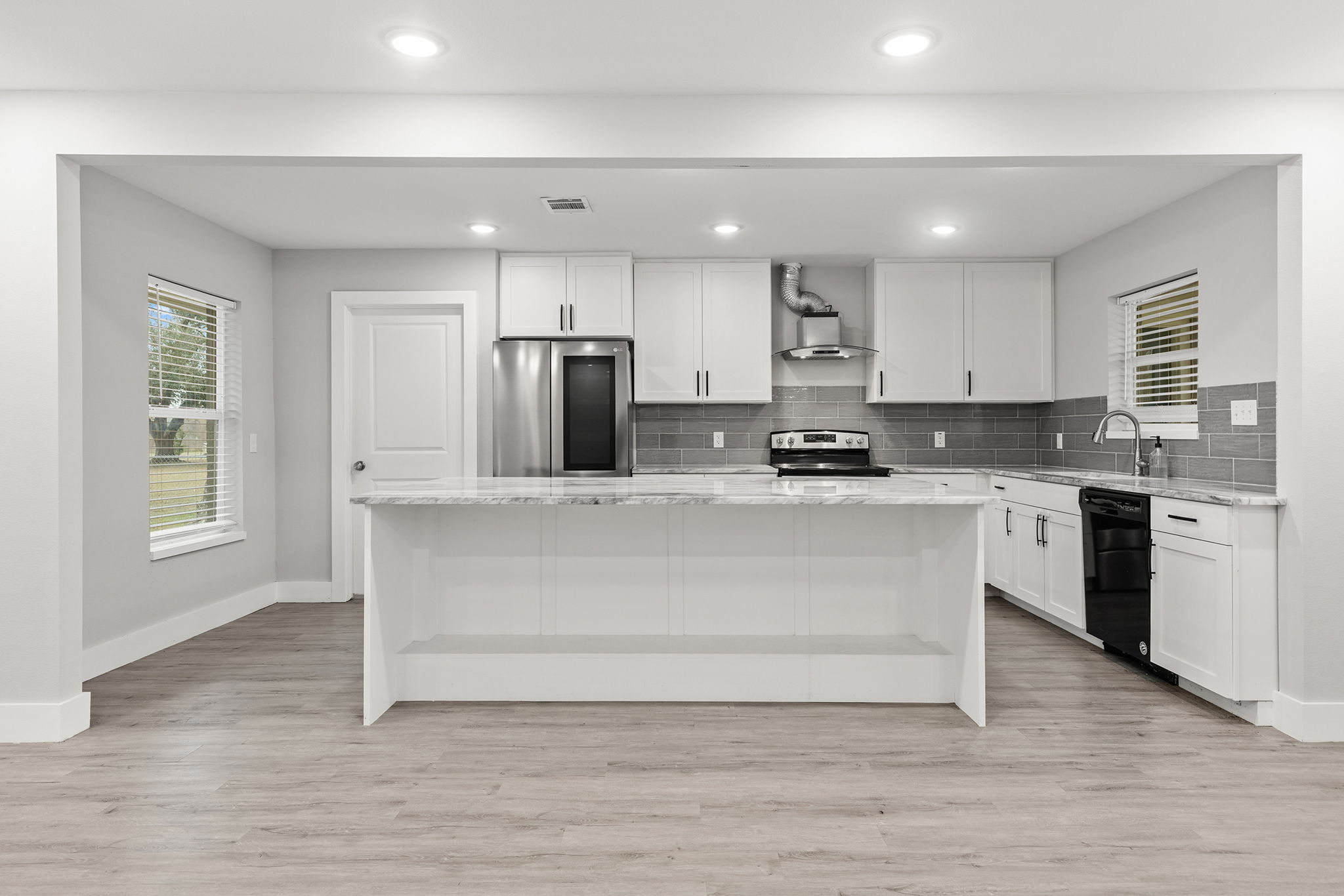 a kitchen with kitchen island white cabinets and stainless steel appliances