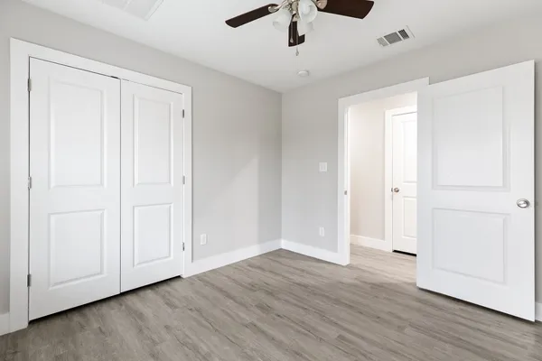 a view of an empty room with kitchen and a window