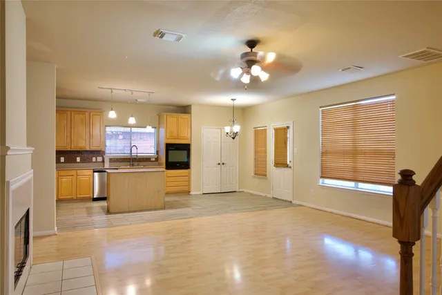 a view of a kitchen with a refrigerator a microwave and a view of living room