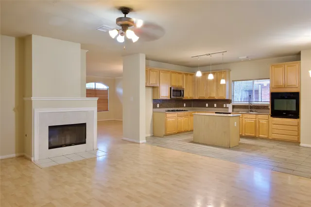 a view of kitchen with granite countertop stove top oven and cabinets