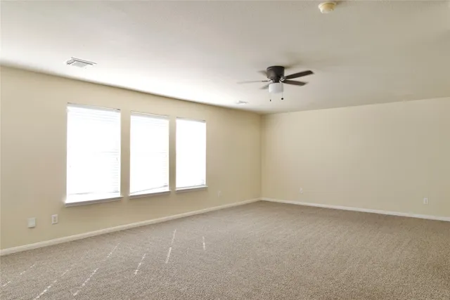an empty room with a window and a ceiling fan