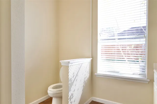 a bathroom with a toilet a sink and a window