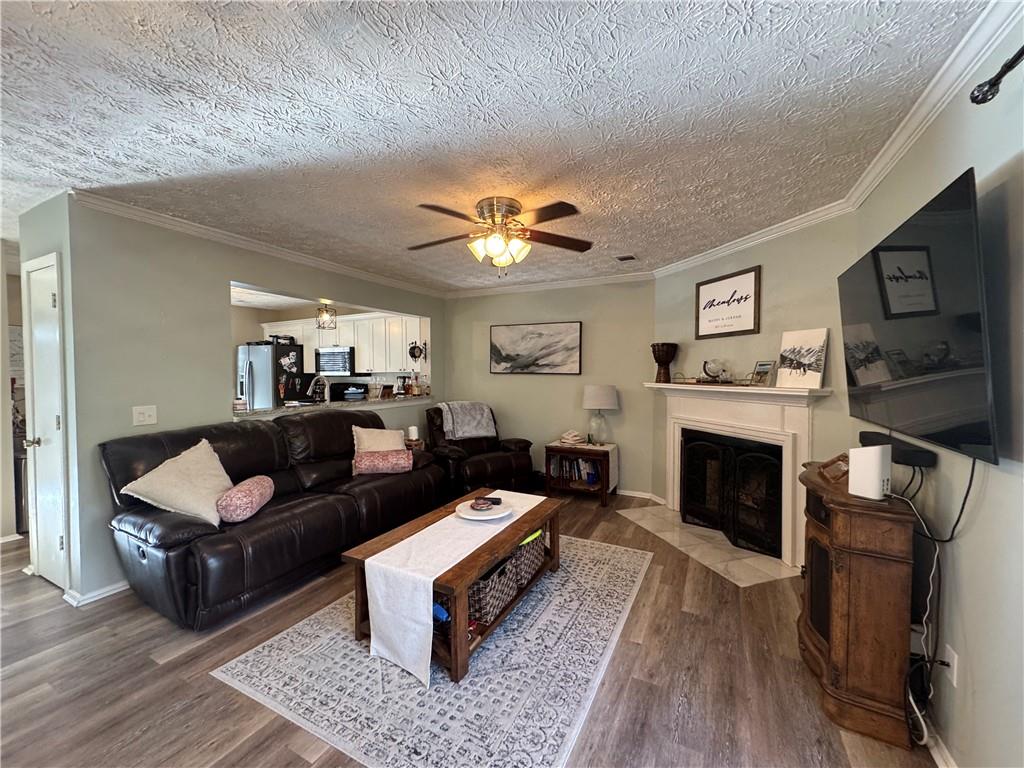 2104 Queen Anne Court Sandy Springs, GA 30350 - Photo 4 of 29 a living room with furniture a fireplace and a flat screen tv
