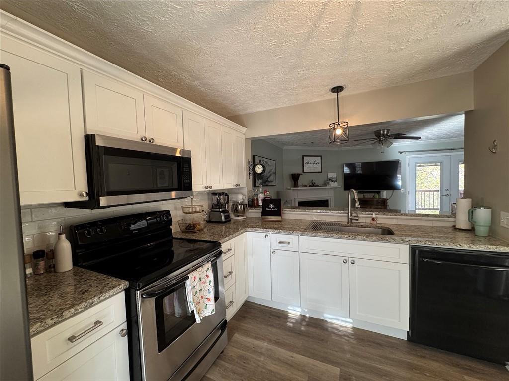 2104 Queen Anne Court Sandy Springs, GA 30350 - Photo 5 of 29 a kitchen with stainless steel appliances granite countertop a sink a stove and a microwave