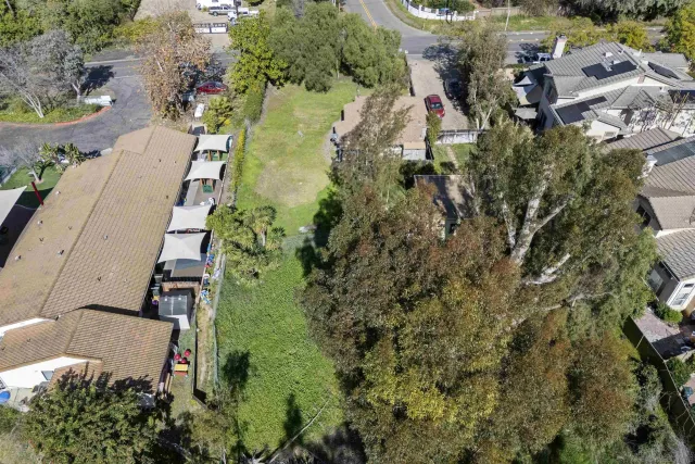 an aerial view of residential house with outdoor space and trees all around